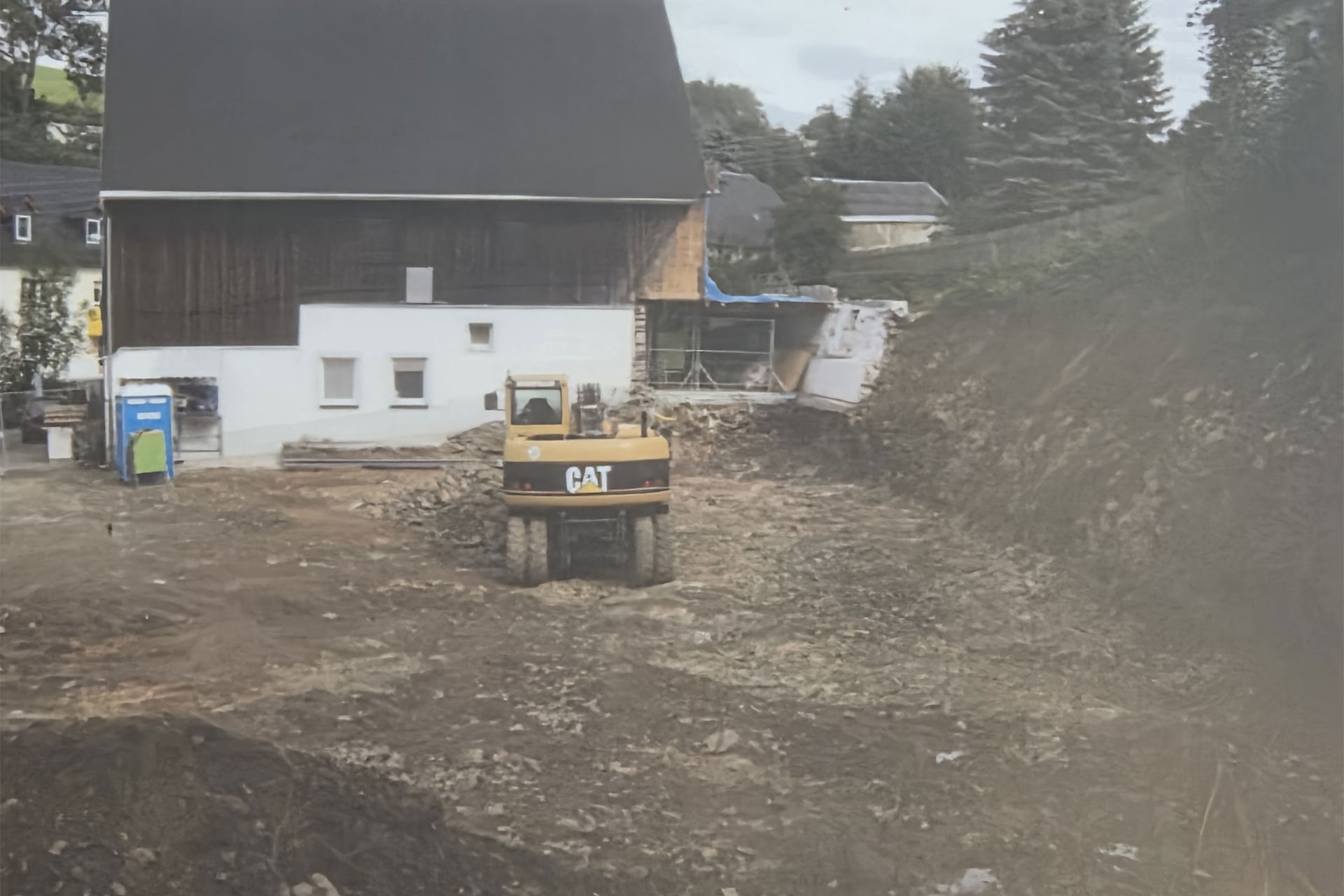 Baustelle des Neubaus gegenüber der historischen Bäckerei Göpfert mit Bagger und Erdarbeiten.