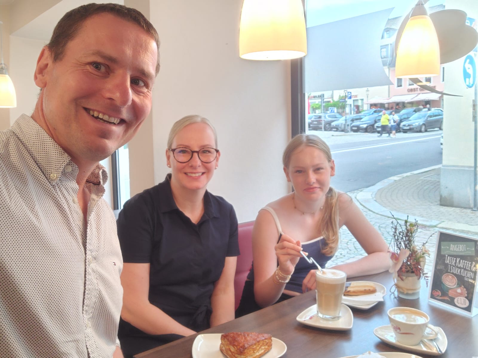 Tobias Lemm mit seiner Frau Janin und Tochter Victoria im Café der Bäckerei Göpfert, gemeinsam lächelnd in die Kamera.